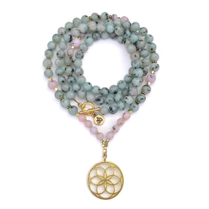 A beaded necklace with light blue-green and pale pink gemstone beads, accented with small gold spacer beads and a gold-tone flower motif pendant, displayed on a clean white background.