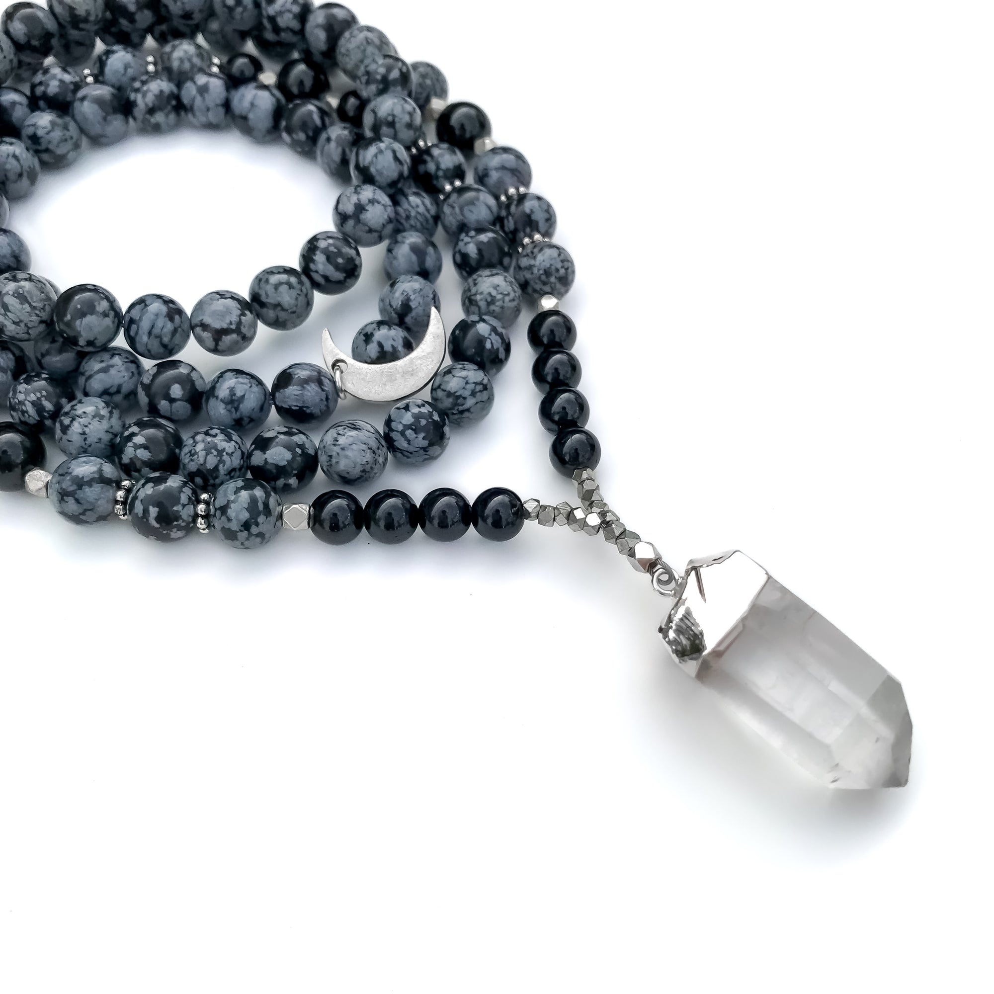 Necklace with black and gray beads and a clear crystal pendant on a white background